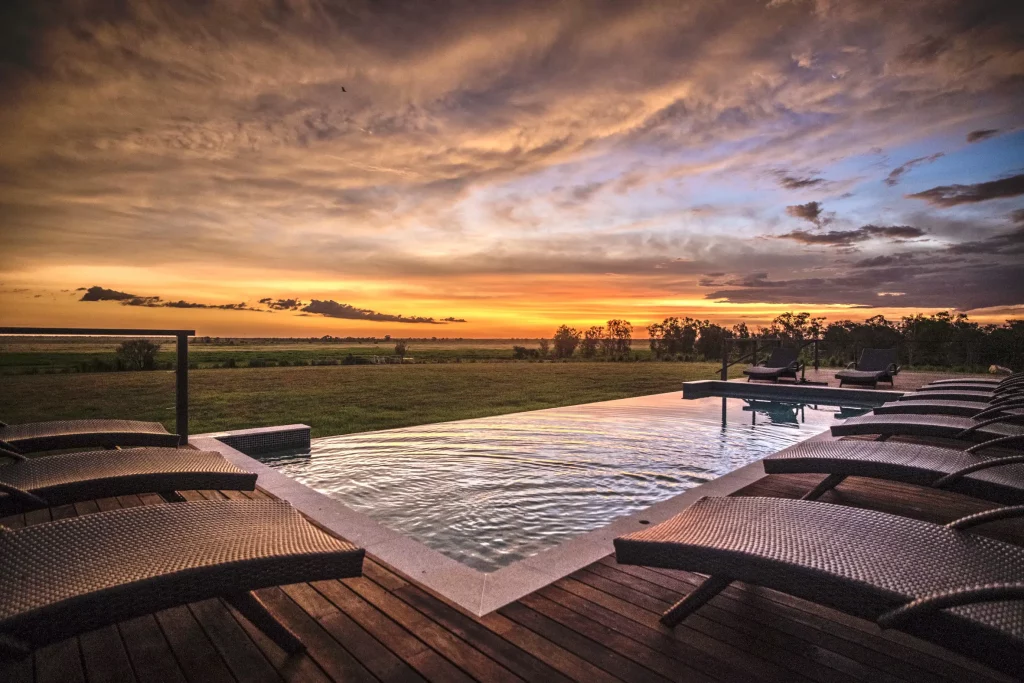 Sunset views from the infinity pool deck at Finniss River Lodge, overlooking lush green floodplain