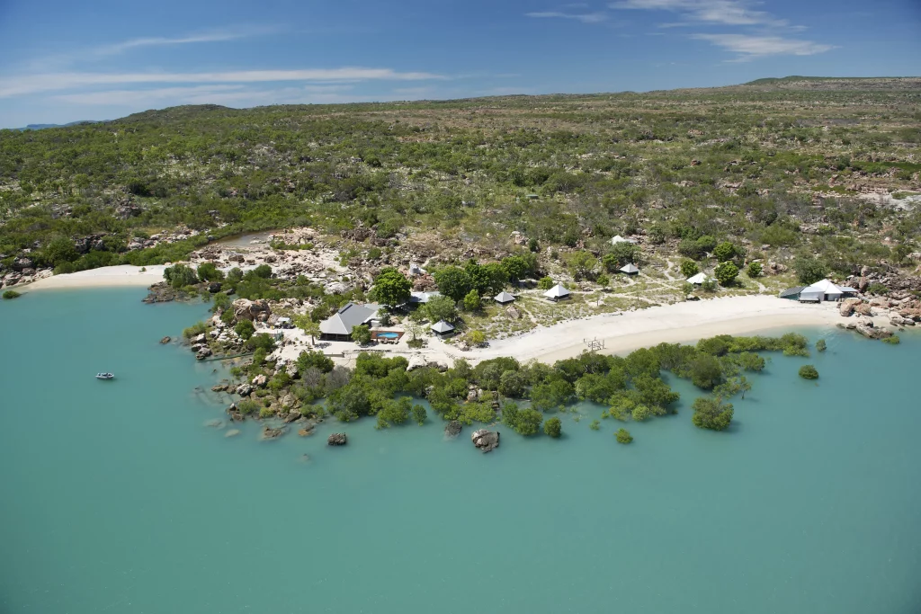 Aerial of Kimberley Coastal Camp on the far edge of Western Australia’s coastline, with green landscapes and blue water on either side of the camp