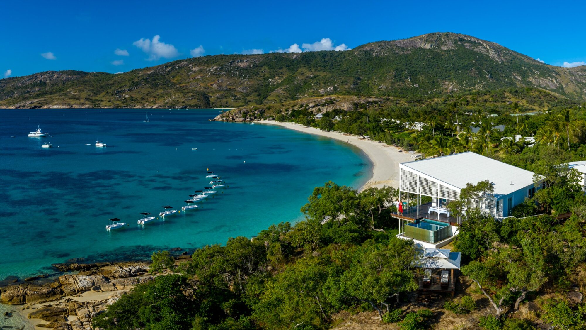 HOus on a private island with white sand beach and boats in the bay 