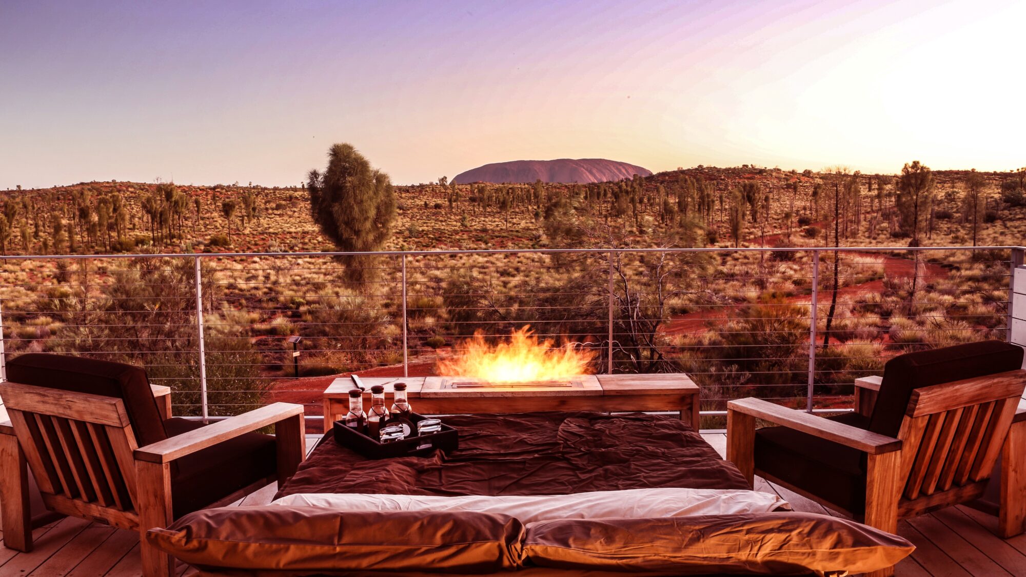 a fire on a deck with a view of Ayers Rock