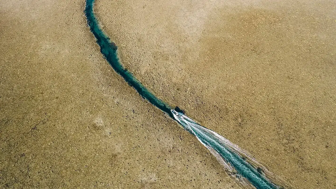 Adventure tender vessel sailing through a channel at Western Australia’s Rowley Shoals