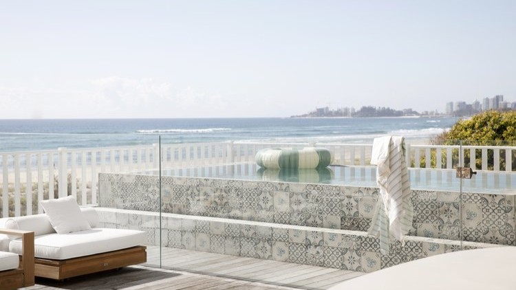 seaside villa with swimming pool and city coastline in the background