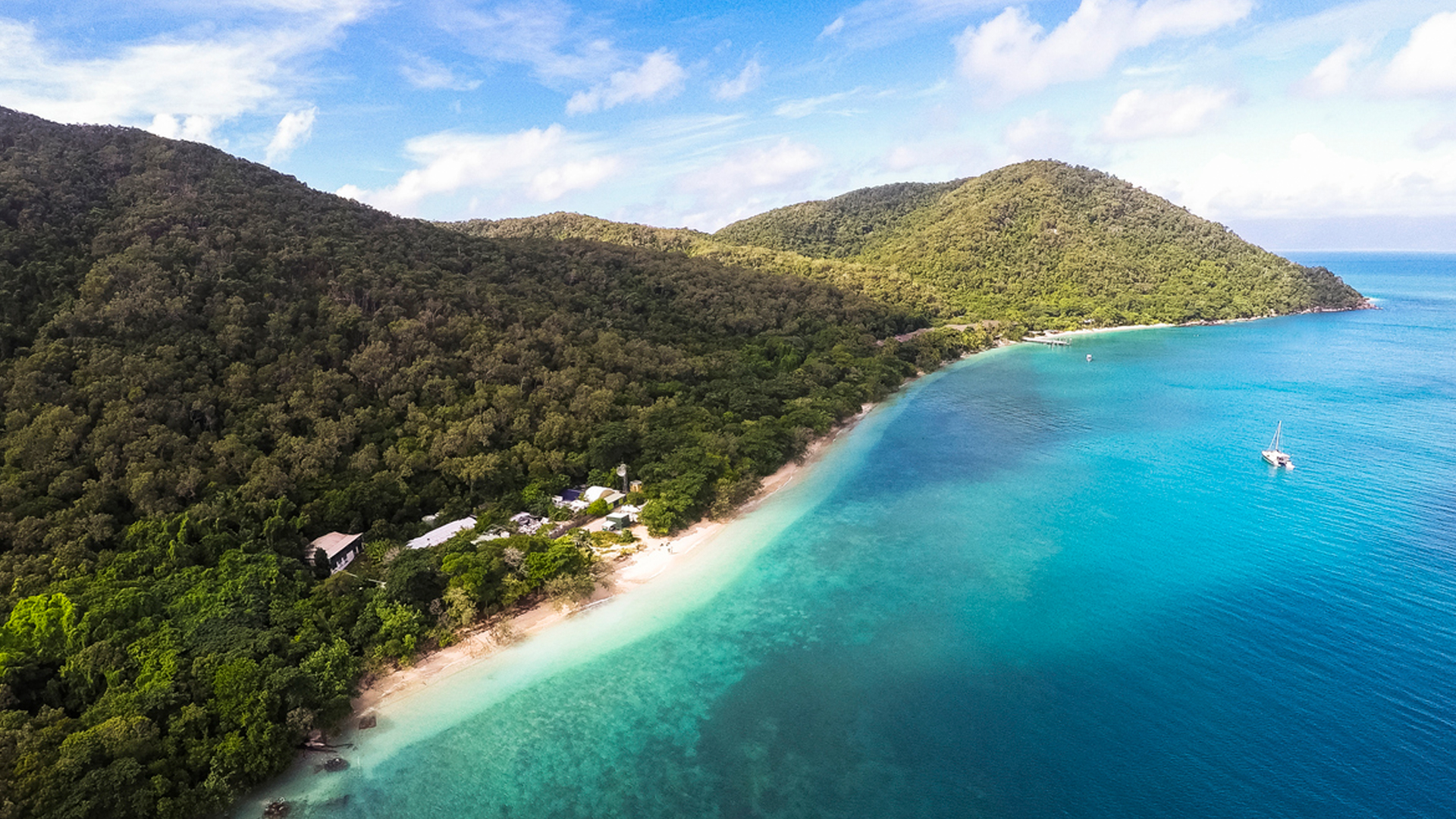 Tropical beach island paradise with sailing yacht moored